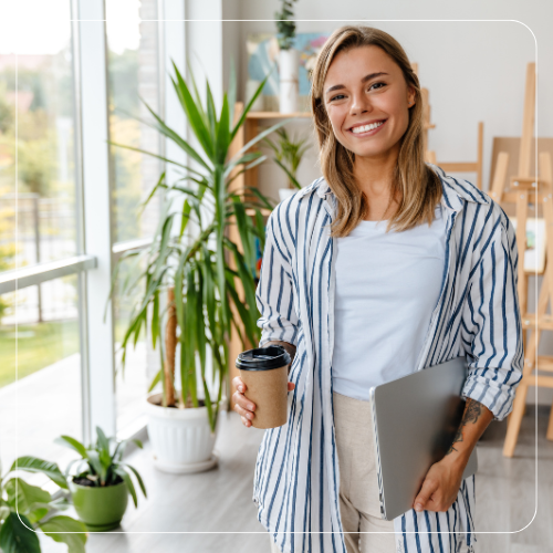 Frau mit Coffee-to-go und Laptop betrachtet Tabelle mit Vorteilen verschiedener Heizsysteme – Stadtwerke Schwarzenberg GmbH, Ihr Energieanbieter vor Ort, informiert.